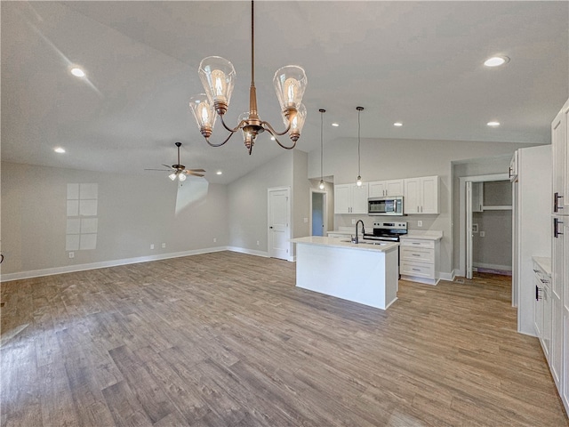 kitchen with an island with sink, decorative light fixtures, light hardwood / wood-style flooring, white cabinetry, and stainless steel appliances