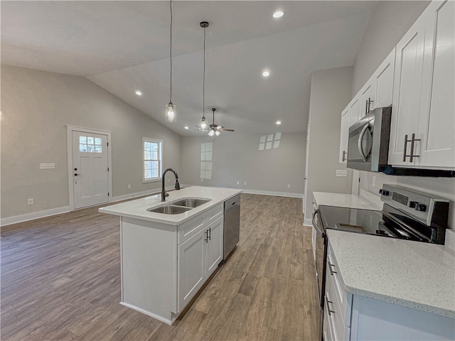 kitchen with sink, hanging light fixtures, appliances with stainless steel finishes, an island with sink, and white cabinetry