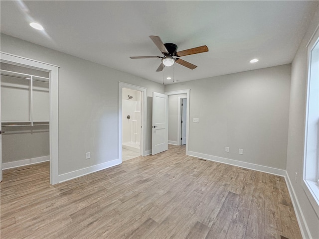 unfurnished bedroom featuring ceiling fan, ensuite bathroom, a closet, and light hardwood / wood-style floors