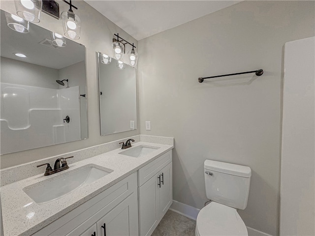 bathroom featuring vanity, walk in shower, and toilet