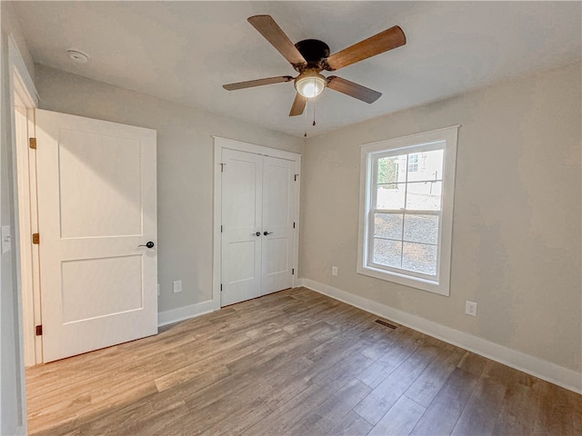 unfurnished bedroom with ceiling fan, a closet, and light hardwood / wood-style floors