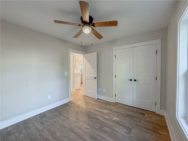 unfurnished bedroom featuring a closet, light hardwood / wood-style flooring, and ceiling fan