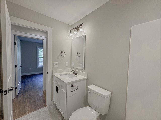 bathroom with wood-type flooring, vanity, and toilet