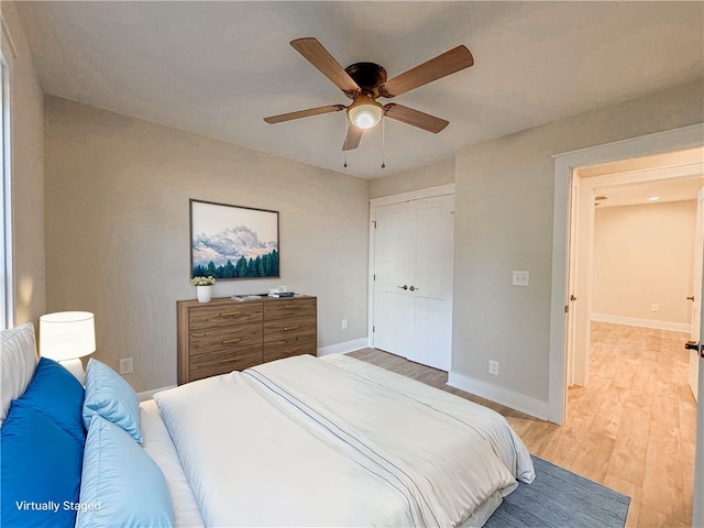 bedroom featuring a closet, light hardwood / wood-style floors, and ceiling fan