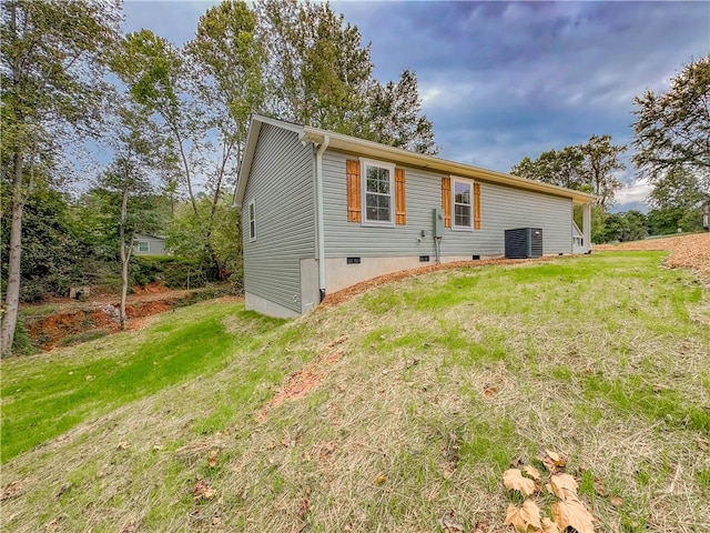 back of house with central AC and a lawn