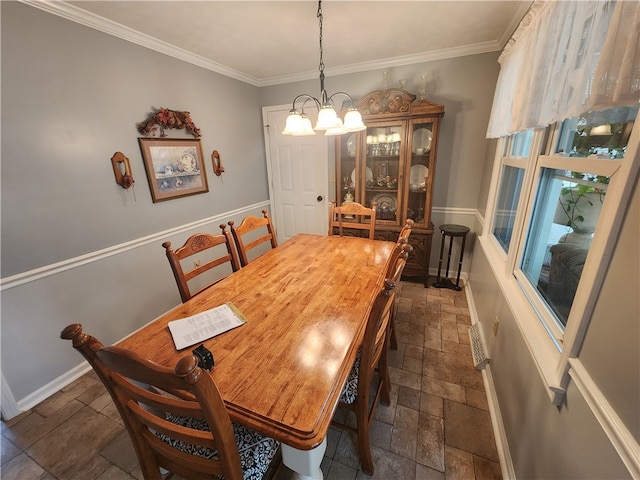 dining space featuring ornamental molding and a notable chandelier