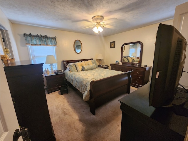 carpeted bedroom with ceiling fan and a textured ceiling