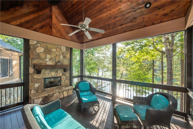 sunroom / solarium featuring wooden ceiling, a fireplace, vaulted ceiling, and ceiling fan