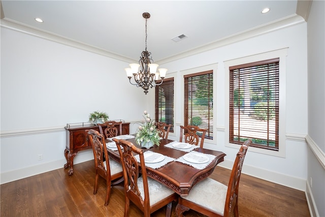 dining area featuring an inviting chandelier, crown molding, and dark hardwood / wood-style floors