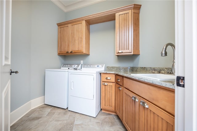 clothes washing area with crown molding, separate washer and dryer, sink, and cabinets