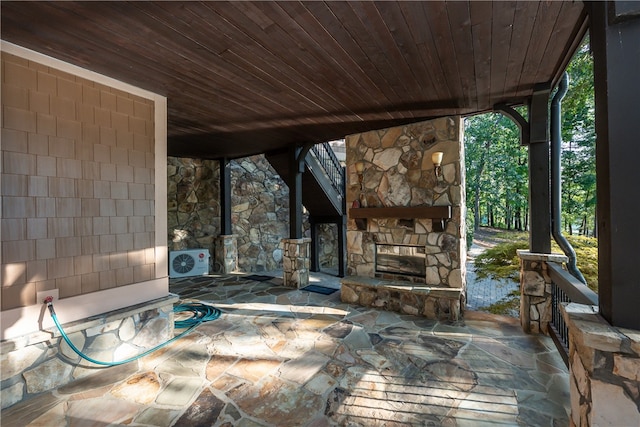 view of patio / terrace featuring ac unit and an outdoor stone fireplace