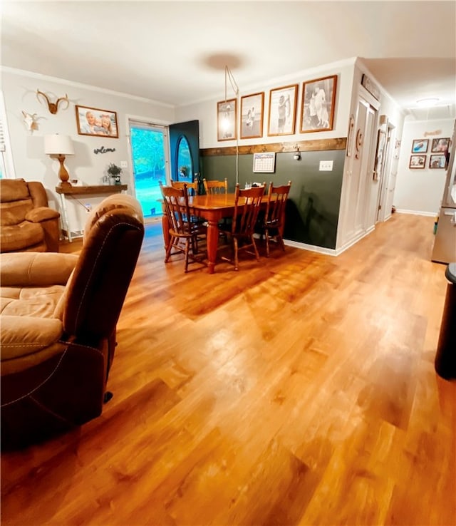 dining space featuring hardwood / wood-style flooring and crown molding