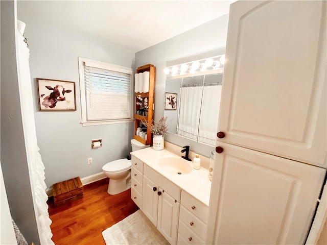 bathroom with hardwood / wood-style floors, vanity, and toilet