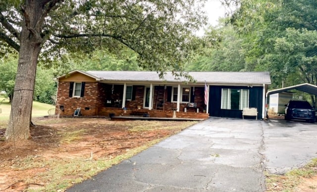 ranch-style home featuring a carport and a porch