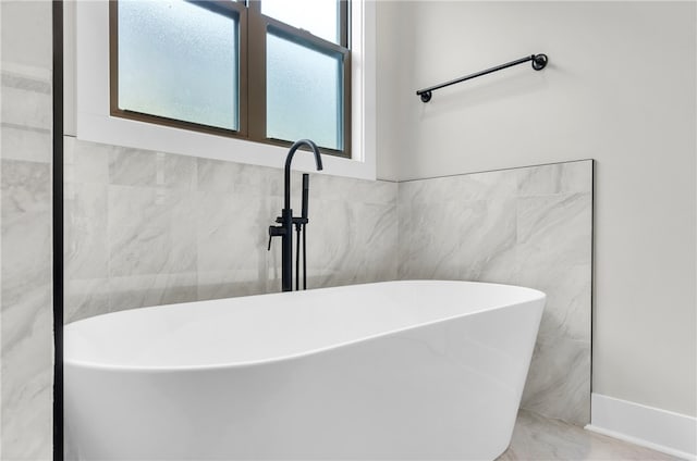 bathroom featuring tile walls and a washtub