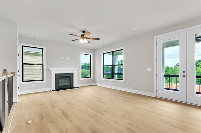 unfurnished living room with ceiling fan, light wood-type flooring, and a healthy amount of sunlight