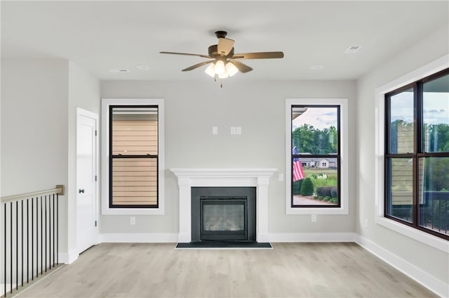 unfurnished living room featuring ceiling fan and light wood-type flooring