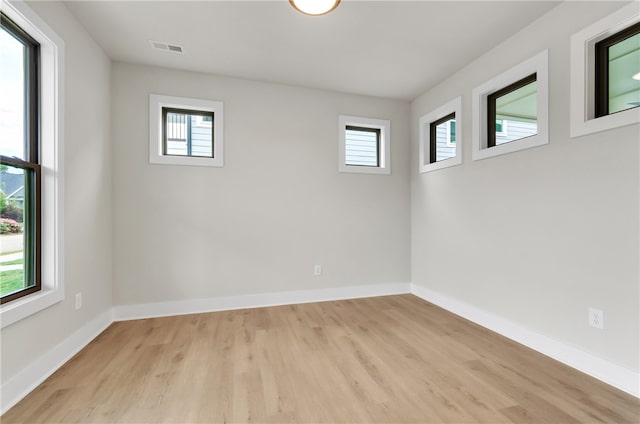 unfurnished room with light wood-type flooring and plenty of natural light