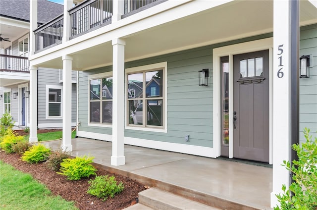 doorway to property featuring a balcony and covered porch