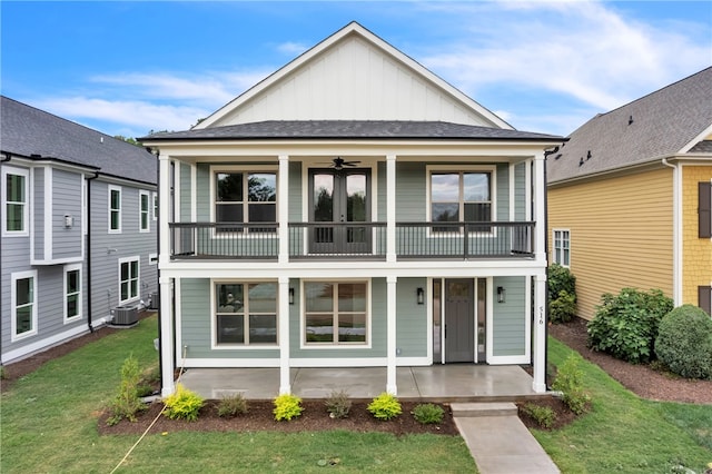 view of front of house featuring cooling unit, a balcony, a front lawn, and ceiling fan