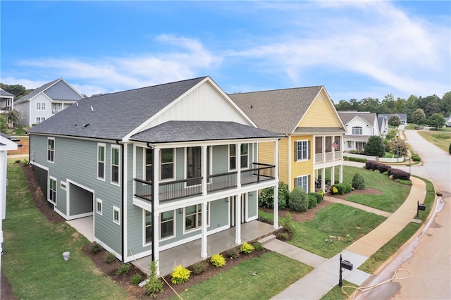 rear view of property with a lawn and a balcony