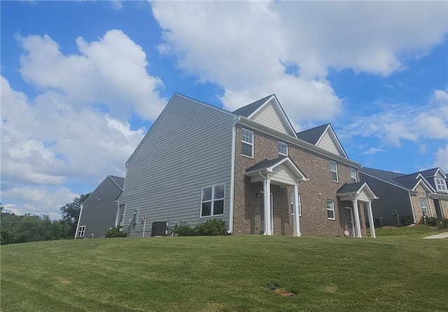 view of property exterior with a lawn and central AC