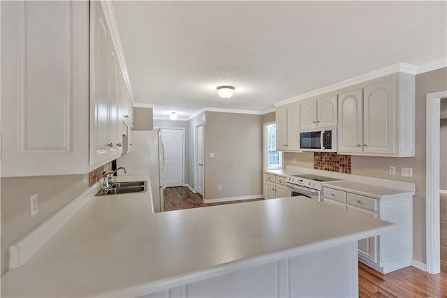 kitchen with white cabinets, white appliances, and kitchen peninsula