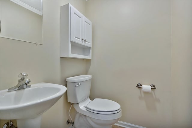 bathroom with ornamental molding, sink, and toilet