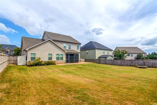 rear view of property with a sunroom and a lawn