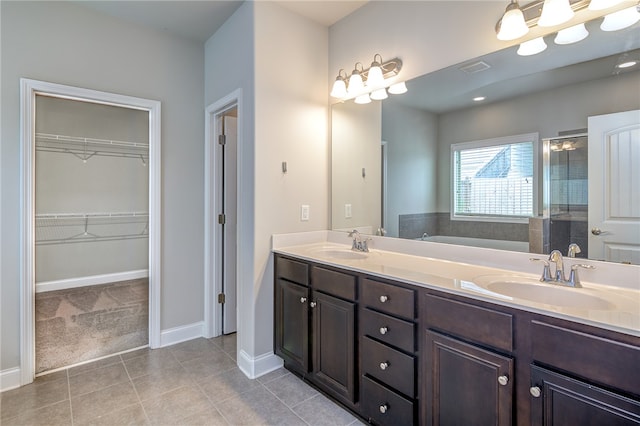 bathroom featuring tile patterned flooring, an enclosed shower, and vanity