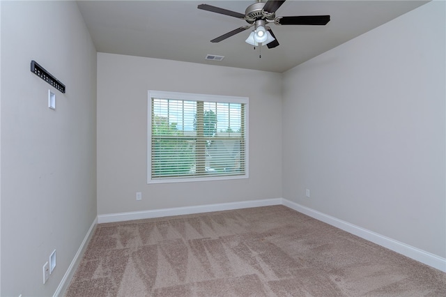 spare room with ceiling fan and light carpet