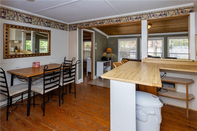 dining room with a wealth of natural light, hardwood / wood-style floors, and crown molding