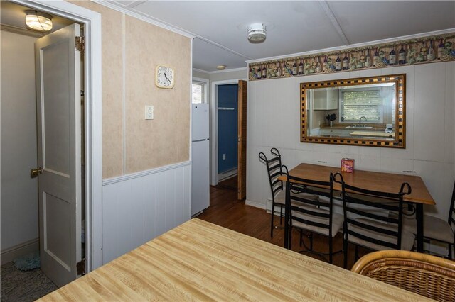 dining room with crown molding, dark hardwood / wood-style floors, and sink