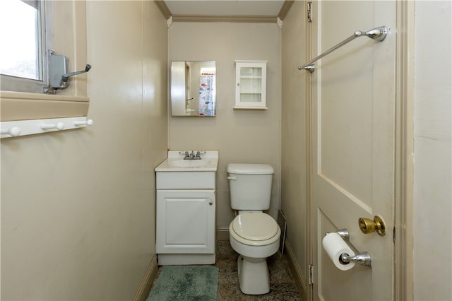 bathroom with ornamental molding, vanity, and toilet