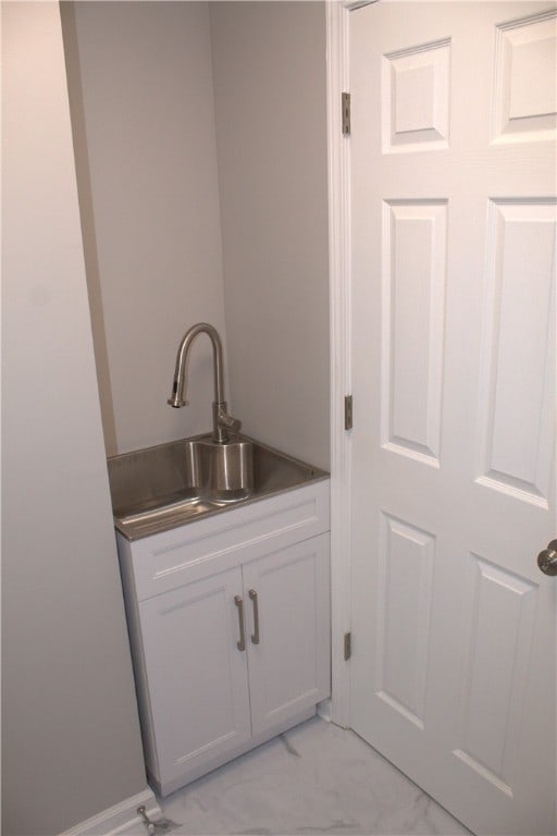 bar featuring white cabinets and sink