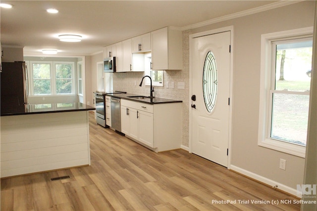 kitchen with light hardwood / wood-style flooring, white cabinets, stainless steel appliances, and sink