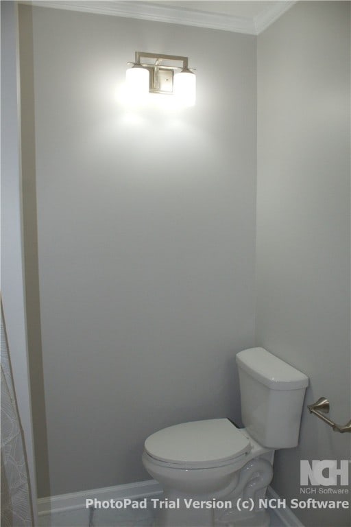 bathroom featuring toilet and crown molding