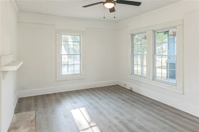 empty room featuring wood-type flooring, ornamental molding, and ceiling fan