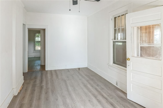 empty room with ornamental molding, light hardwood / wood-style floors, and ceiling fan