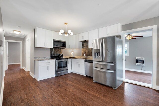 kitchen with stainless steel appliances, white cabinets, dark wood-type flooring, and decorative light fixtures