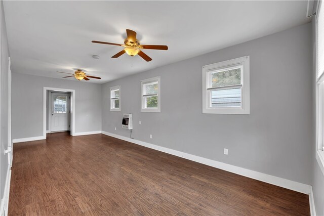 empty room featuring heating unit, ceiling fan, and dark hardwood / wood-style floors