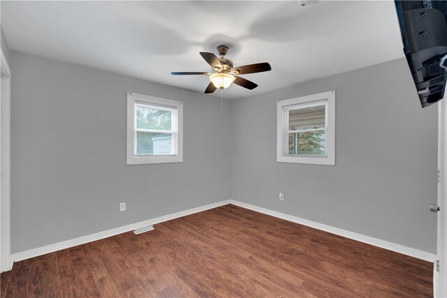 empty room featuring ceiling fan and dark hardwood / wood-style flooring