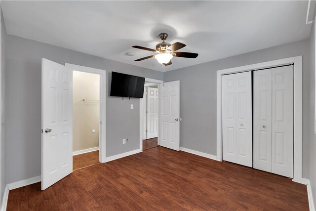 unfurnished bedroom featuring dark hardwood / wood-style floors, ceiling fan, and a closet