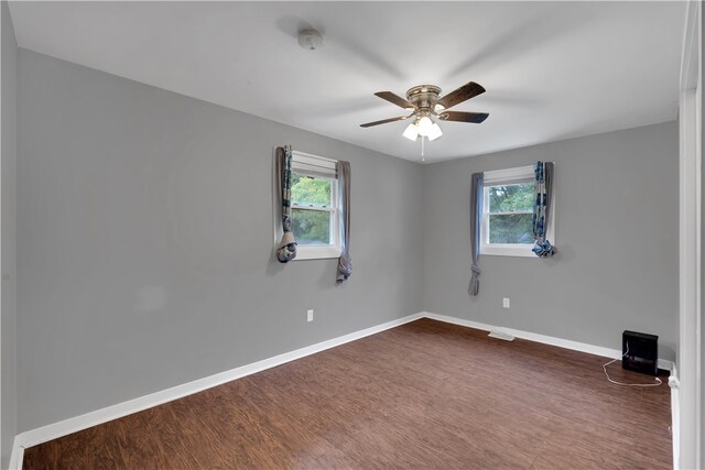 spare room with ceiling fan, dark hardwood / wood-style floors, and a healthy amount of sunlight