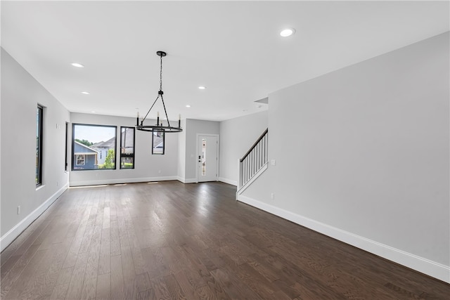 unfurnished dining area featuring an inviting chandelier and dark hardwood / wood-style floors