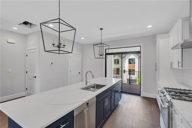 kitchen with sink, white cabinets, stainless steel appliances, a center island with sink, and blue cabinetry