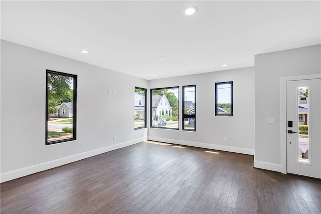 spare room featuring dark wood-type flooring and a healthy amount of sunlight