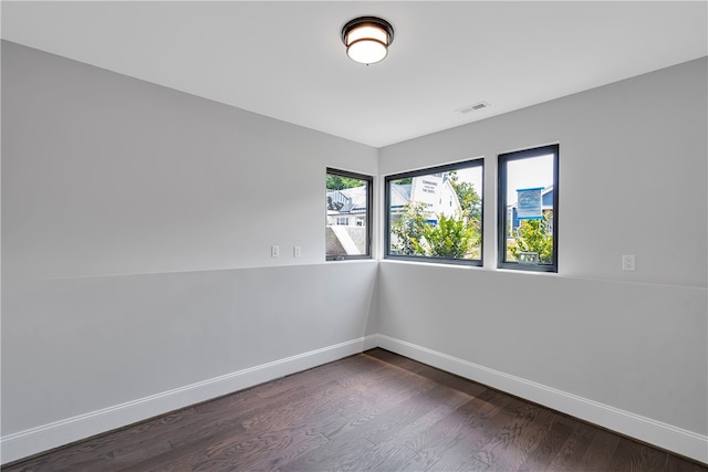 unfurnished room with dark wood-type flooring