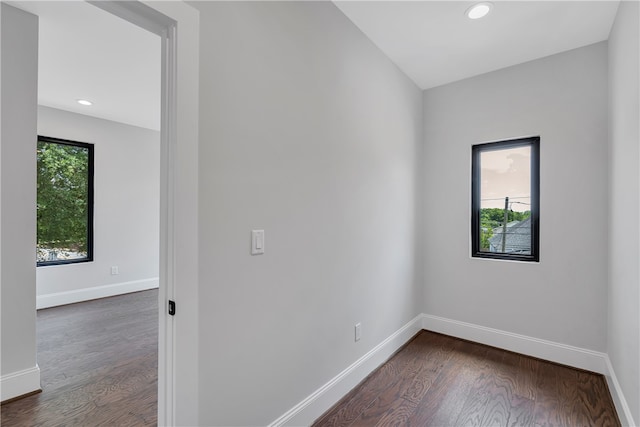 empty room with dark wood-type flooring and a wealth of natural light