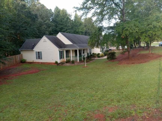 exterior space with covered porch and a yard